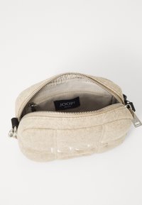 Borsa di lana beige con chiusura a zip, caratterizzata da una morbida texture, una piccola tasca interna e un'etichetta con logo all'interno.
