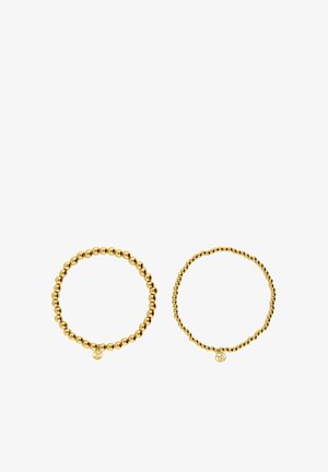 Deux bracelets élastiques dorés, l'un avec de plus grosses perles sphériques et l'autre avec de petites perles uniformes. Les deux sont ornés d'un charm pendentif.