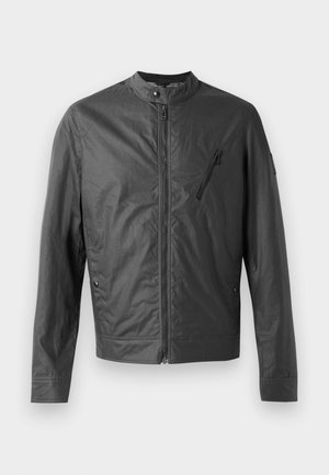 Giacca leggera nera con colletto alto, chiusura con zip frontale e tasca con zip sul petto. Tessuto texture, vestibilità aderente.