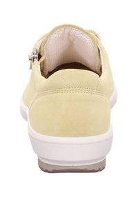 Helle gelbe Wildlederschuhe mit einer abgerundeten Rückseite, weißer Sohle und Netzfutter. Besitzen einen kleinen silbernen Reißverschluss an der Außenseite.
