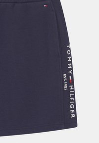 Marinefarbene Jersey-Shorts mit lockerer Passform, auf der linken Seite mit "TOMMY HILFIGER EST. 1985" in Weiß gestickt und einem Logosticker.