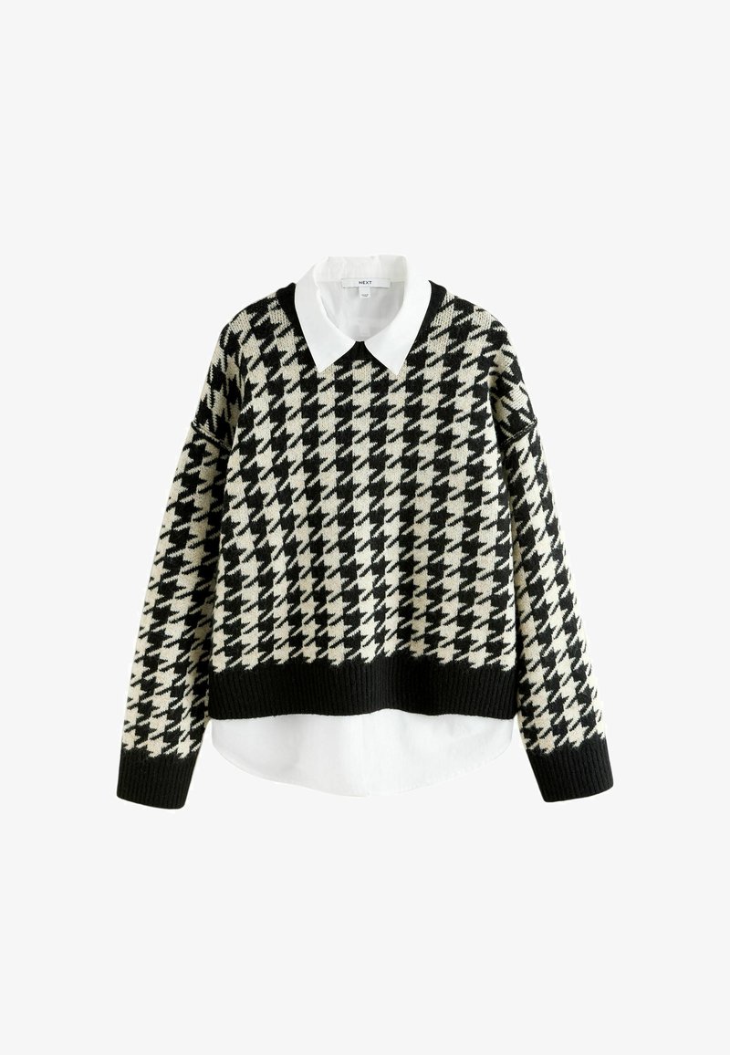 Pull en motif pied-de-coq noir et crème avec une chemise blanche à col en dessous. Présente un design court avec des poignets et un ourlet côtelés.