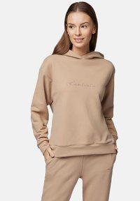 Beżowa bluza z kapturem wykonana z miękkiego materiału, z przednią kieszenią i haftowanym logo. Długie rękawy z prążkowanymi mankietami i dołem.