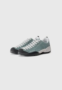 Sportowe buty w szmaragdowym zamszu z szarym gumowym czubkiem i białymi sznurowadłami. Posiadają teksturowany język oraz formowaną podeszwę z przyczepnością.