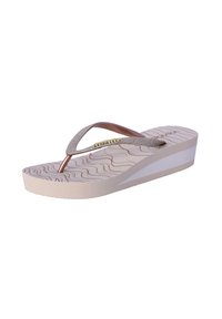 Chanclas de plataforma en color beige con suela de goma. Presentan una tira texturizada y brillante adornada con una fila de detalles metálicos.