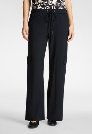 Zwarte broek met wijde pijpen en een zachte, vloeiende structuur, voorzien van een elastische tailleband, trekkoord en zijzakken met klep. Minimalistisch ontwerp.