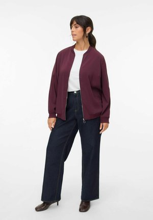 Burgundy bomber jacket with a front zipper, paired with high-waisted wide-leg dark denim jeans and brown heeled boots.