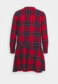 Robe à carreaux rouge et noire à manches longues avec une taille froncée et des poignets boutonnés, vue de dos sur fond blanc.