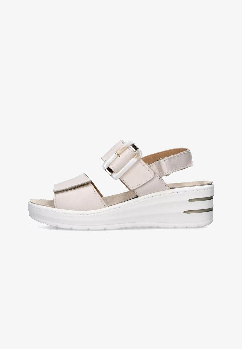 Sandalo con zeppa color beige chiaro dotato di due cinghie regolabili e accenti metallici. Presenta una suola piatta bianca con scanalature orizzontali per una migliore aderenza.