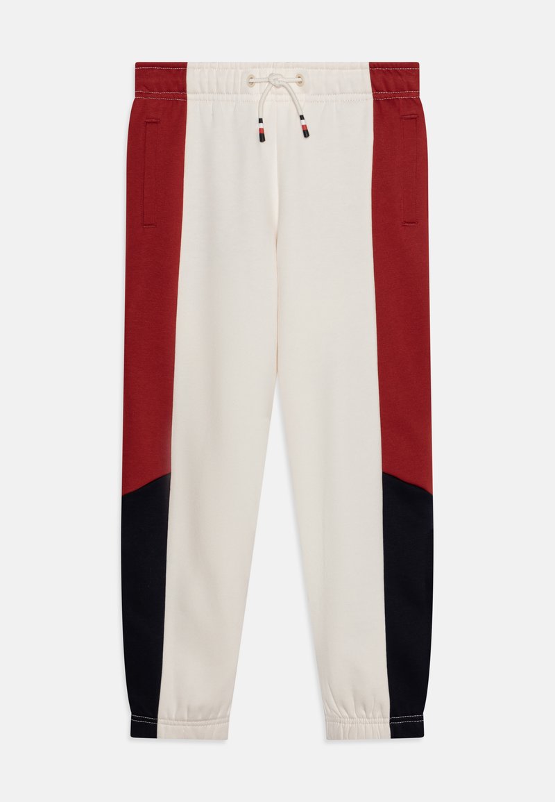 Pantaloni da tuta da uomo con un corpo crema e pannelli laterali neri e rossi, vita elastica con cordino e tasche laterali.
