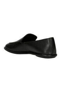Black leather slip-on loafer with low heel and rounded toe, shown from rear-side angle on white background.