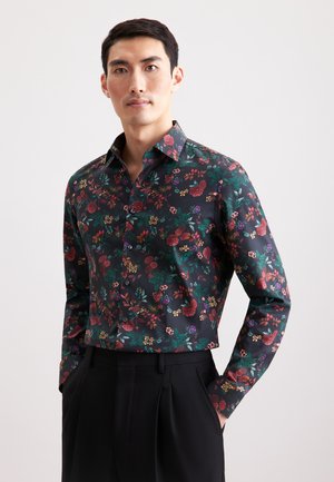 Blumenshirt in Dunkelgrün mit verschiedenen bunten Blumen und Blättern. Lange Ärmel, Knopfverschluss und spitzer Kragen.