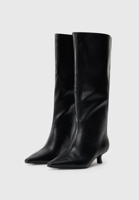 Knee-high black leather boots with a pointed toe, smooth texture, and a low kitten heel, featuring a sleek and minimalist design.