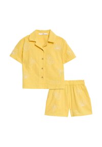 Geel linnen tweedelig set bestaande uit een overhemd met kraag en korte mouwen, versierd met geborduurde ananas- en palmmotieven, en bijpassende shorts met elastische tailleband.