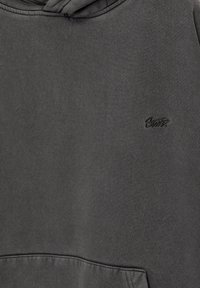 Hanorac gri dintr-un material moale, având o buzunar frontal și un logo embossat pe partea stângă a pieptului. Textură netedă cu un design casual.