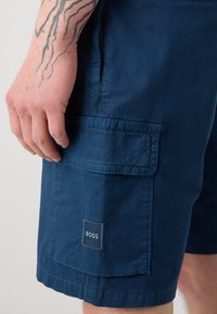 Shorts cargo bleu marine en tissu léger, dotés d'une poche latérale et d'un petit logo carré "BOSS".