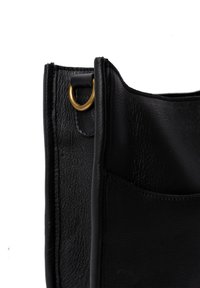 Sort læder tote bag med en tekstureret overflade, der har en guldfarvet metalring og en sidelomme til opbevaring. Enkelt, funktionelt design.