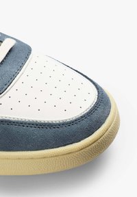 Wildleder- und Ledersneaker mit einer weißen, perforierten Zehenbox, blauem Obermaterial und cremefarbener Gummisohle. Verfügt über kontrastierende Nähte und ein abgerundetes Design.