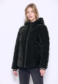Giubbotto imbottito nero con zip frontale e cappuccio. Presenta un motivo trapuntato e polsini elasticizzati. Materiale morbido e design a taglio dritto.