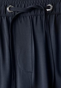 Shorts bleu marine à cordon de serrage en tissu lisse avec une taille, dotés d'un œillet en métal argenté et d'un détail de poche latérale.