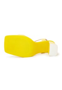 Gelber High Heel Sandale mit eckiger Zehenpartie und einem weißen Blockabsatz. Sie hat eine glatte Textur und ein minimalistisches Design.