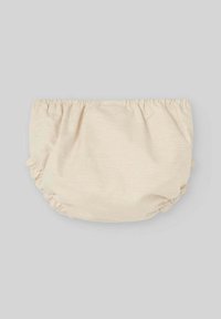 Copridibucato in tessuto beige con bordi elastici arricciati. Presenta una superficie tessurizzata, progettata per il comfort e una facile vestibilità.