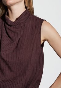 Mauve ärmelloses Top mit Halslinie, das ein strukturiertes Rippenmuster und einen subtilen Schimmer aufweist.