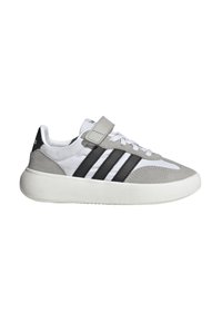 Sneaker grigio e bianco con strisce nere, materiali in tessuto e suede, punta arrotondata, strap in Velcro e suola in gomma texturizzata.