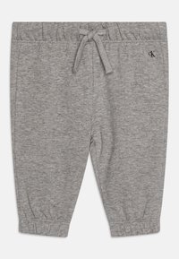 Pantaloni tuta grigi realizzati in tessuto morbido, dotati di una vita elastica con cordoncino e polsini elasticizzati alla caviglia.