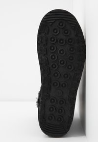 Semelle de chaussure en caoutchouc noir avec motifs de bande de roulement circulaires et griffes en zigzag, indiquant la taille 37 au centre.