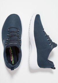 Scarpe da ginnastica blu navy con tomaia in rete, lacci elastici e suola in gomma bianca. Presentano il marchio "Skechers Memory Foam" in colori vivaci.