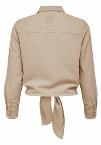 Collared, cropped shirt in beige with brown vertical stripes. Features long sleeves with button cuffs and a tied back detail. Smooth texture.