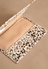 Plånbok med leopardmönstrat tyg och en slät, beige insida, med en ficka för kort eller sedlar och en vikbar design.