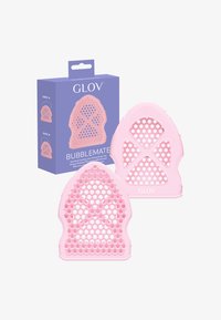 Cuscinetti esfolianti per il corpo in silicone rosa con design perforato, esposti accanto a una scatola di imballaggio viola etichettata "GLOV Bubblemate."