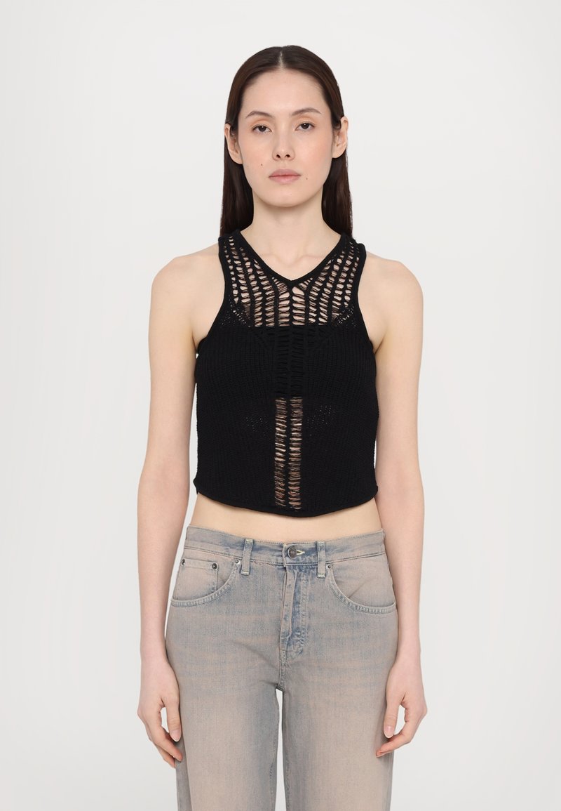 Black knitted cropped top featuring a V-neck and open weave pattern, paired with light blue high-waisted jeans. Minimal detailing visible.