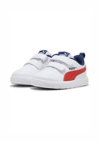 Baskets blanches avec des accents rouges et bleu marine, dotées d'un dessus en synthétique lisse, de deux bandes Velcro, et d'une semelle en caoutchouc texturée.