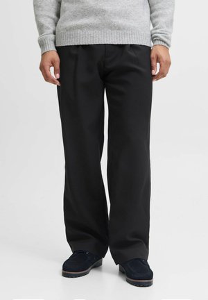 Black wide-leg trousers made of smooth fabric with a slight sheen. Features a relaxed fit and minimalistic design, worn with dark shoes.