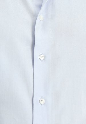 Hellblaues Button-Up-Hemd aus strukturiertem Stoff, das vorne sechs weiße Knöpfe hat, mit glatter Oberfläche und ohne Muster.