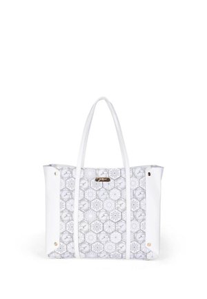 Biała torba na ramię z geometrycznym wzorem sześciokątów, długimi uchwytami i małą metalową plakietką z logo na środku przodu.