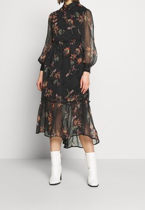 Black floral dress with sheer long sleeves, high collar, and tiered skirt. Features colorful floral patterns against a textured background.