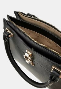 Borsa a mano in pelle nera con design strutturato, chiusura con zip superiore, hardware dorato e interno foderato con logo, dotato di più scomparti.
