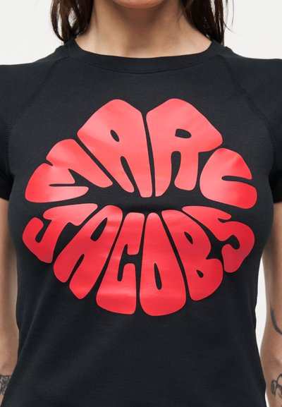 Μαύρο μπλουζάκι με έντονα, κόκκινα, στρογγυλεμένα γράμματα στο κέντρο του στήθους που γράφουν "EARLS TACO LABS" με στυλιζαρισμένη, καμπυλωτή γραμματοσειρά.