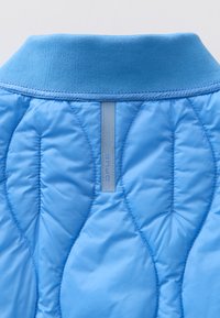 Doudoune bleu clair avec un motif matelassé texturé. Dotée d'un col côtelé et d'une petite étiquette logo au dos. Fini lisse.