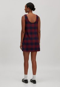 Rot und marineblau karierter ärmelloser Kleid mit rundem Rückenausschnitt, aus strukturiertem Stoff; hat ein ausgestelltes Design, knielangen Schnitt und eine lockere Passform.