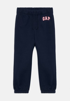 Pantalons de survêtement bleu marine pour enfants avec taille élastique, cordon de serrage, poignets froncés et logo "GAP" rouge sur la hanche gauche.
