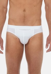 Weiße Baumwollslips mit glatter Textur, ausgestattet mit einem breiten elastischen Bund und konturiertem Beutel-Design zur Unterstützung.