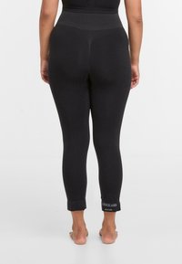 Zwarte leggings met een hoge tailleband, taps toelopende pasvorm en opgerolde boorden met een geprinte logo aan de zoom. Glad, rekbaar stoftextuur.
