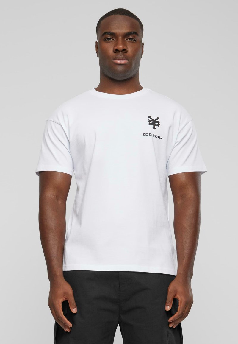Hvid bomulds t-shirt med et lille sort Zoo York-logo på venstre bryst, med korte ærmer og rund halsudskæring.