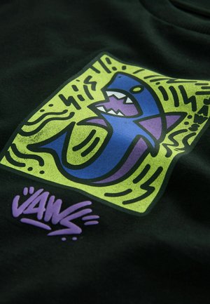 Czarna koszulka z wyrazistą grafiką niebieskiej rekina z purpurową paszczą, na zielonym tle z falistymi liniami oraz napisem "VANS" w kolorze purpurowym.