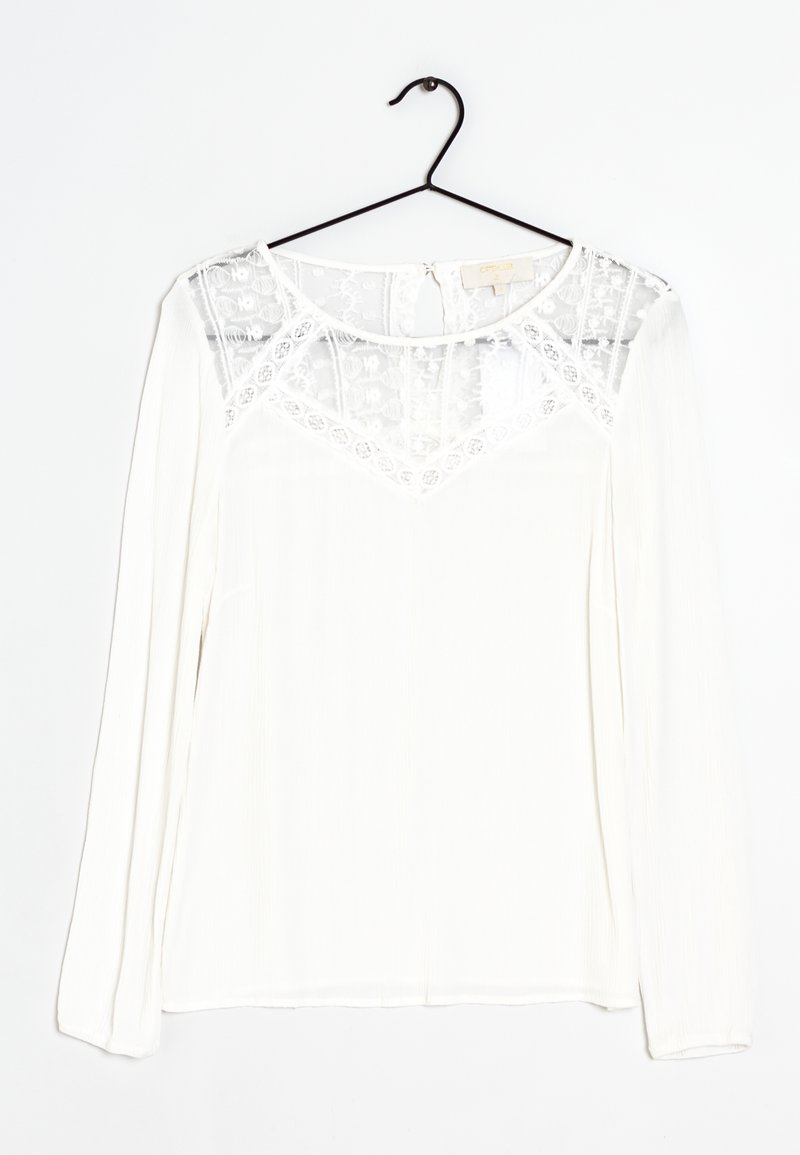 Blusa bianca a maniche lunghe con un pannello in pizzo trasparente all'collo e tessuto testurizzato. Orlo arrotondato e chiusura a gancio sul retro.